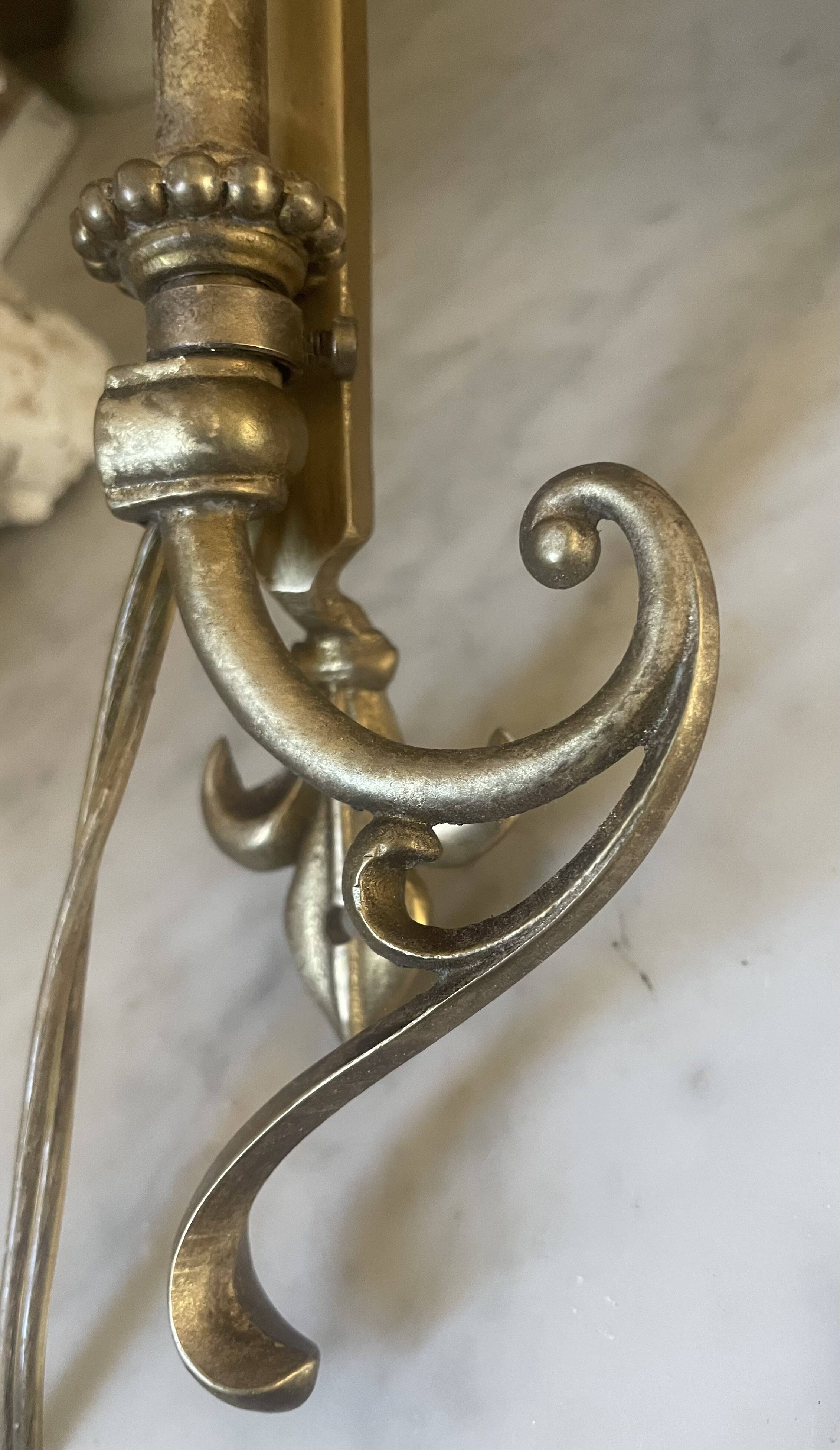 Adjustable wall light in brass and gold metal.