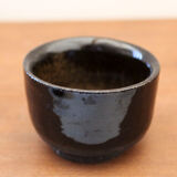 Set of 8 black ceramic cups signed