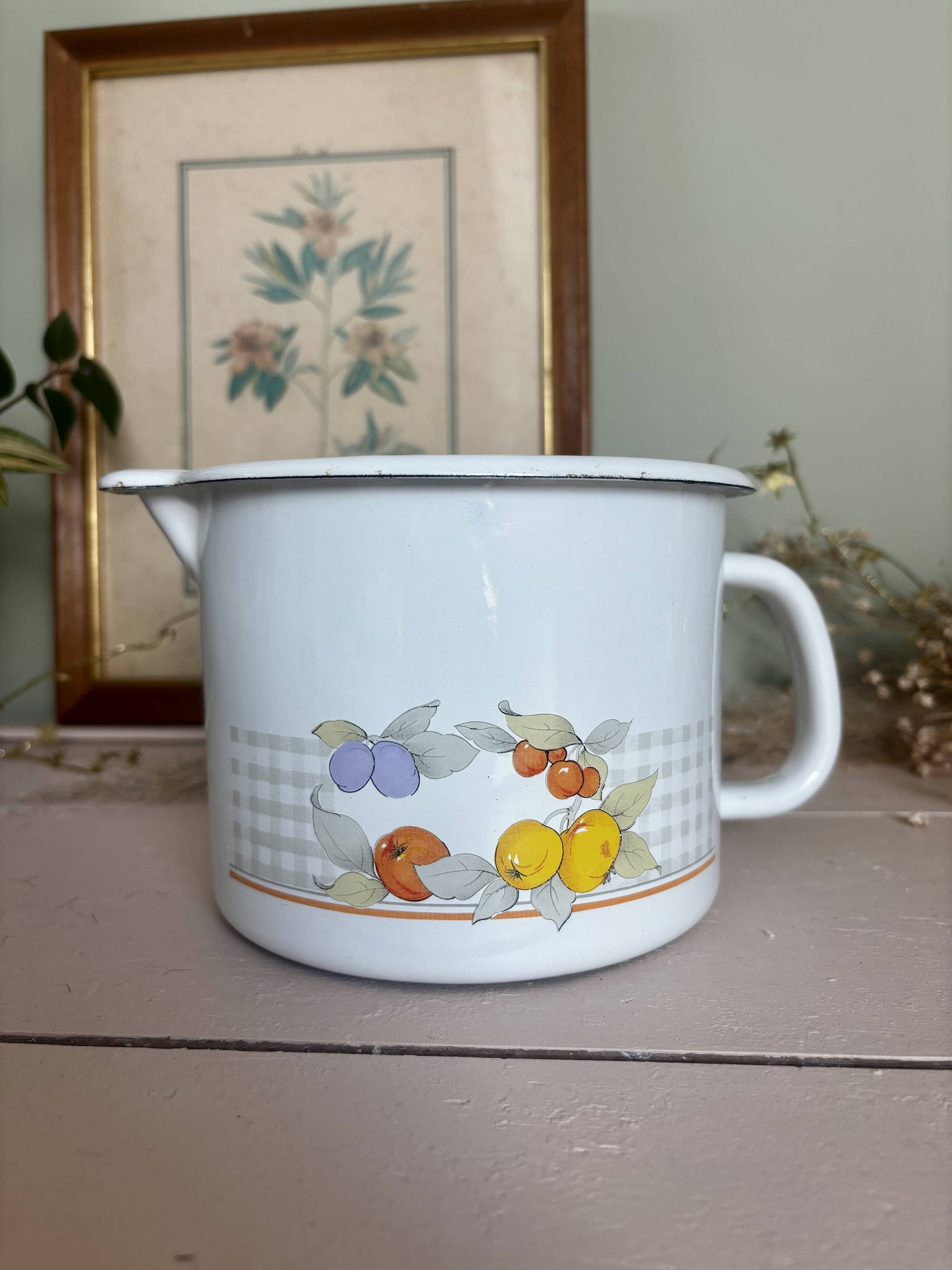 Vintage enamelled white metal milk jug with fruits.