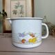 Vintage enamelled white metal milk jug with fruits.