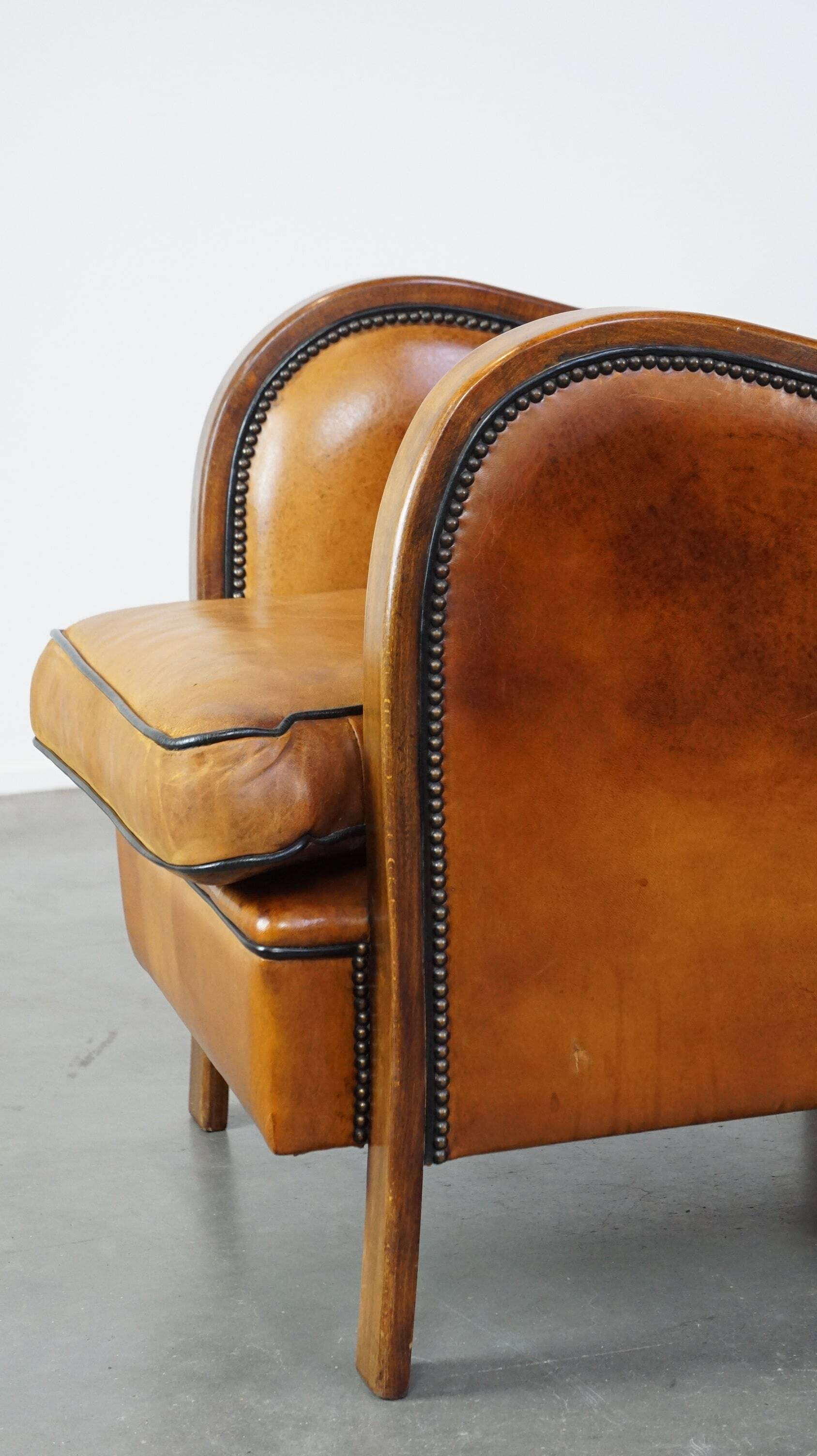 Unique, luxurious sheepskin armchair combined with wood and finished with decorative nails