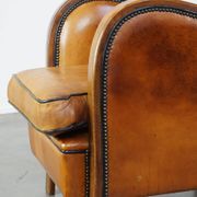 Unique, luxurious sheepskin armchair combined with wood and finished with decorative nails