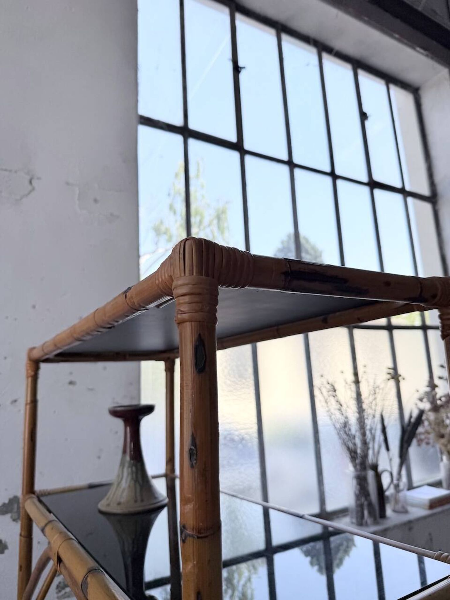 Rattan bookshelf and black glasses