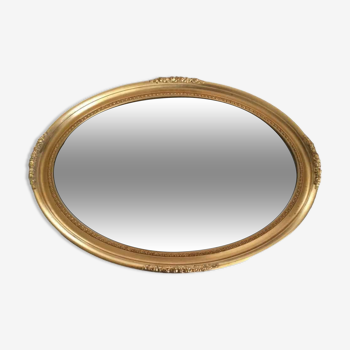 Beveled oval mirror with carved gilded wood frame