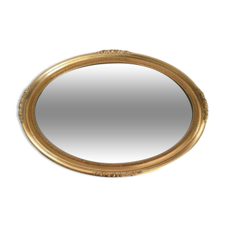 Beveled oval mirror with carved gilded wood frame