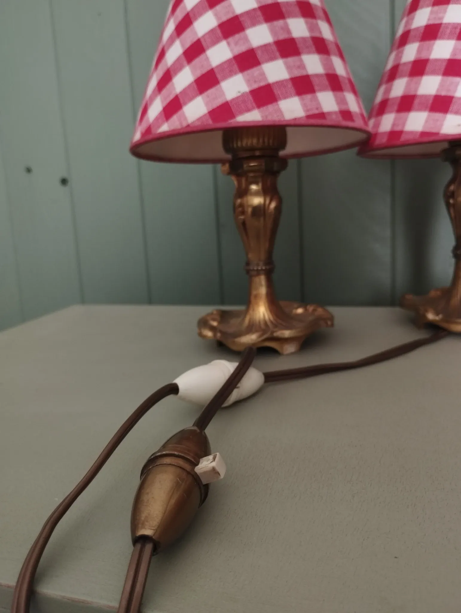 Pair of small lamps in gilded bronze by Petitot and red gingham lampshades.