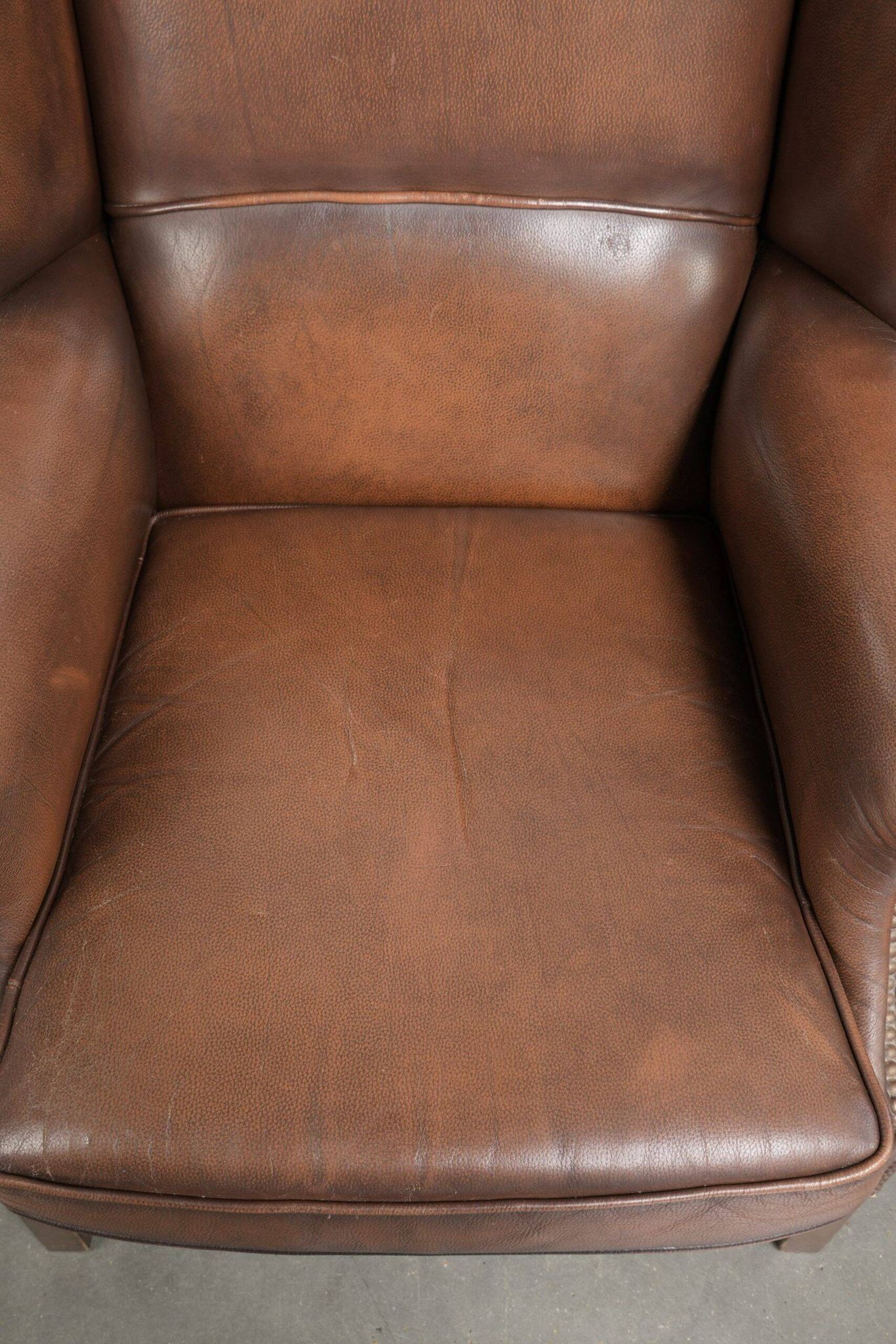 Ensemble de 2 fauteuils à oreilles en cuir de vache de style anglais.