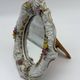 Antique porcelain mirror from Dresden with relief flowers and rococo decoration.