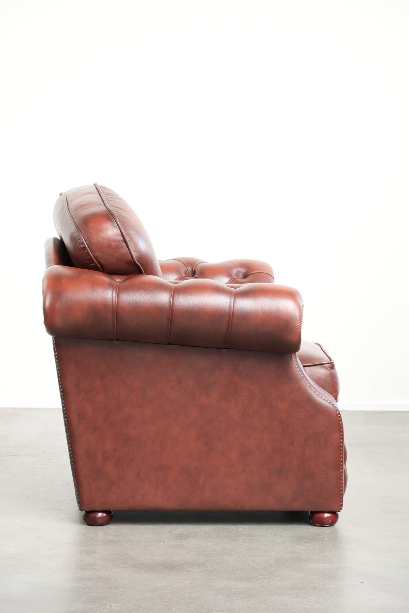 Cowhide chesterfield armchair in a warm brown colour with decorative nails