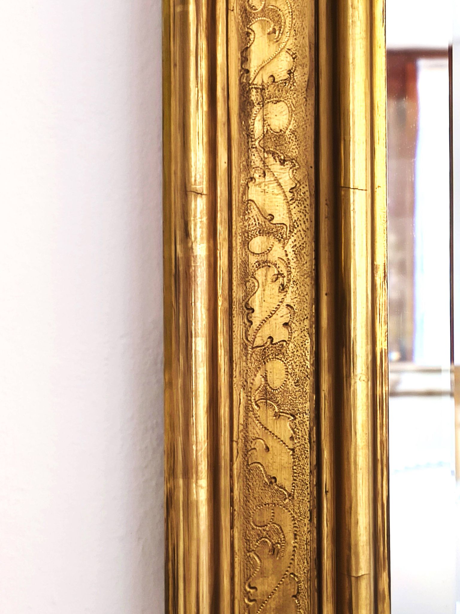 Florentine arched mirror in gilded wood with gold leaf.