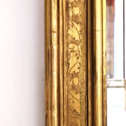 Florentine arched mirror in gilded wood with gold leaf.