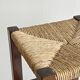 Vintage stool in dark wood with a woven straw seat.