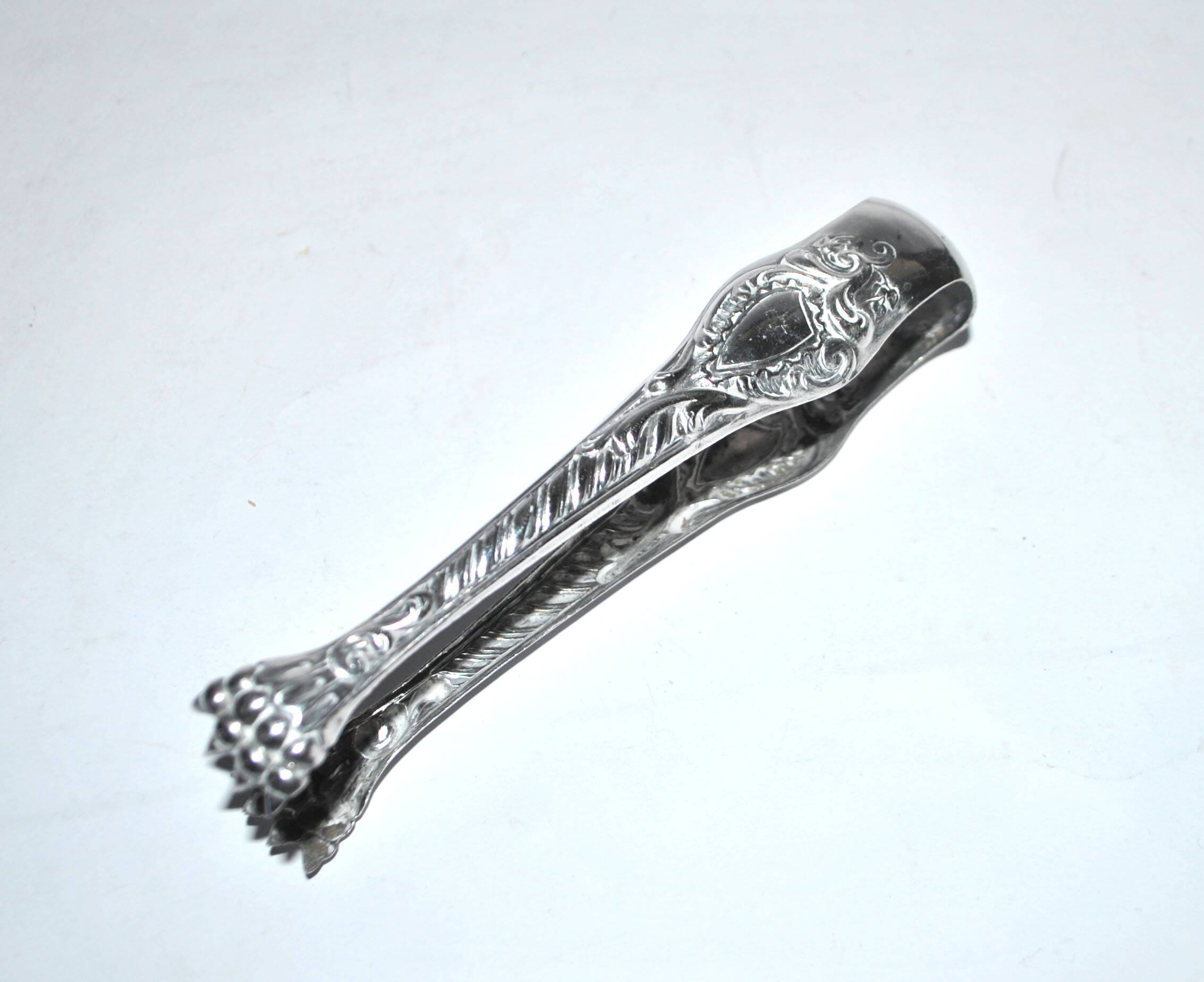 Rocaille sugar tongs in silver metal with lion claw medallion