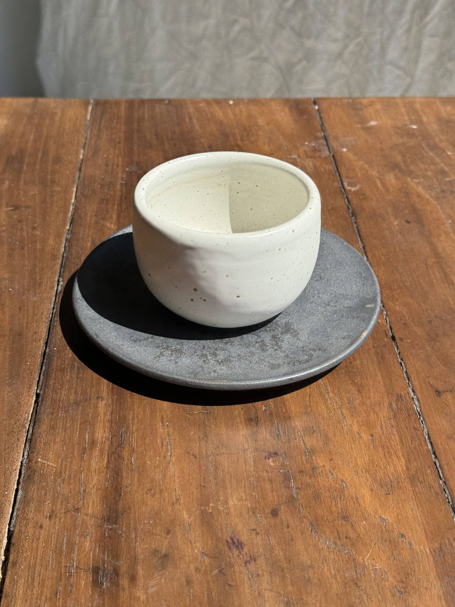 Tasse blanche en céramique indonésienne et soucoupe grise