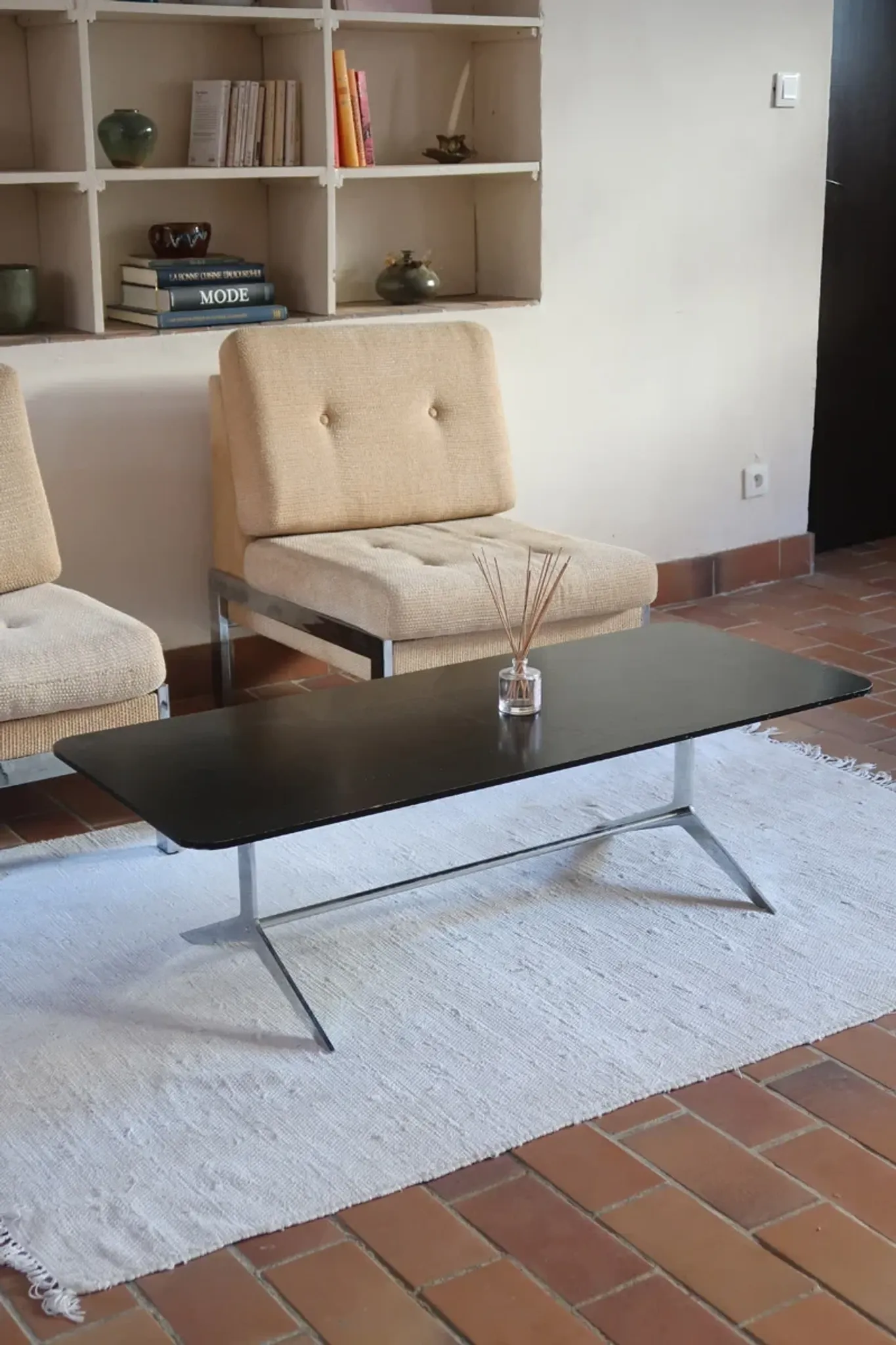 70s design coffee table with a black top and steel legs.
