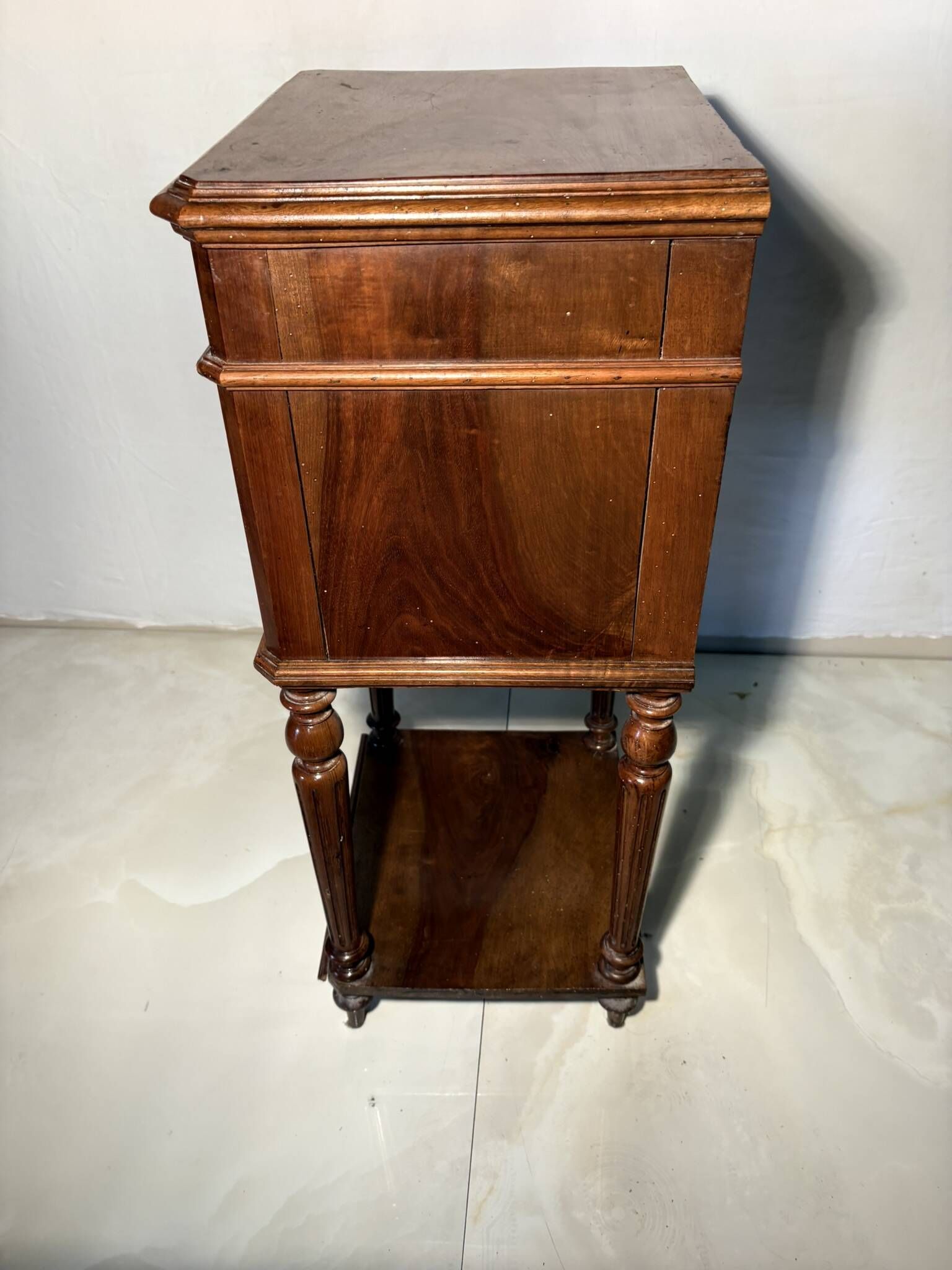 Antique wooden bedside table with turned legs.