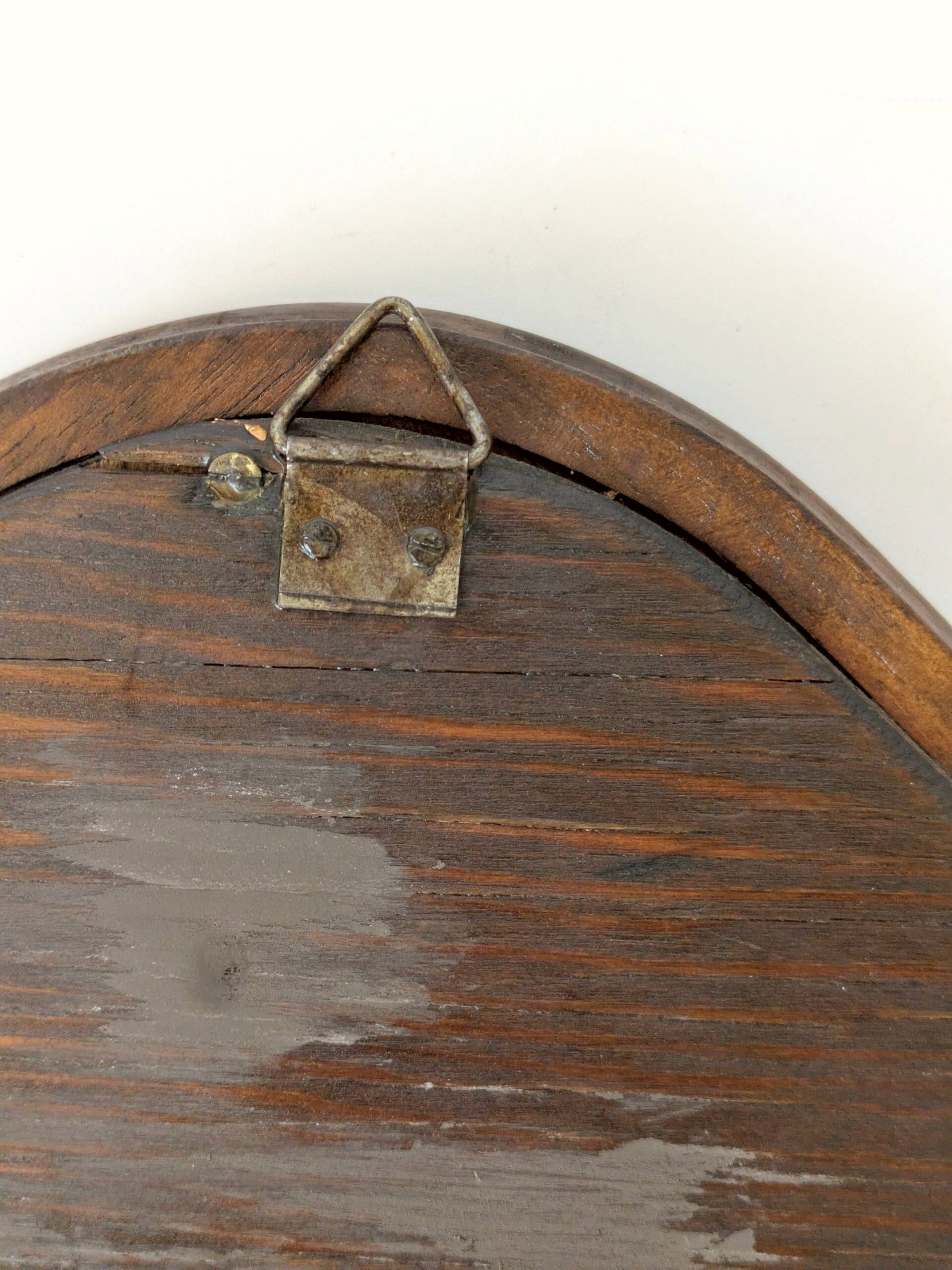 Antique wall mirror in carved wood with a wavy shape and a golden trim.