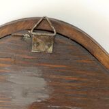 Antique wall mirror in carved wood with a wavy shape and a golden trim.