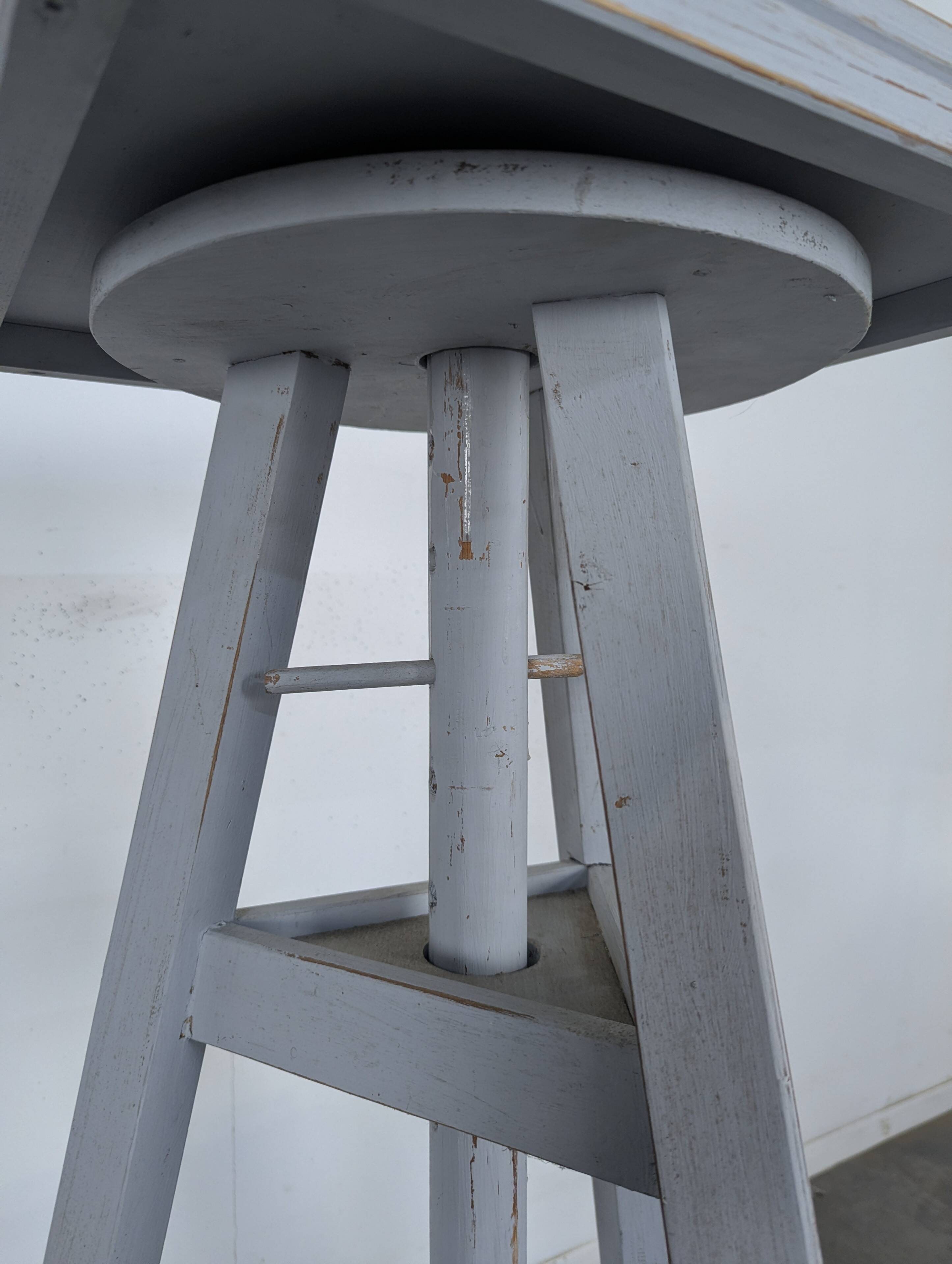 Tripod sculptor's stool in grey painted wood with a rotating top.