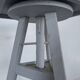 Tripod sculptor's stool in grey painted wood with a rotating top.