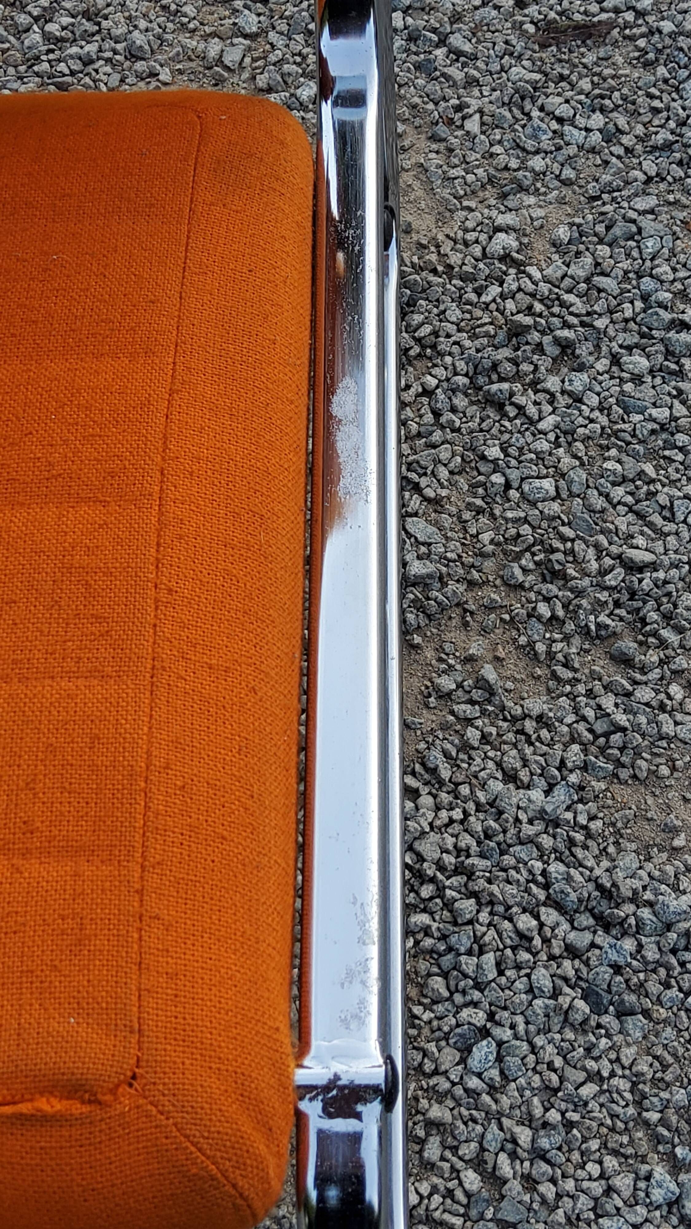 Pair of designer armchairs in orange fabrics and chrome tubes from the 70s