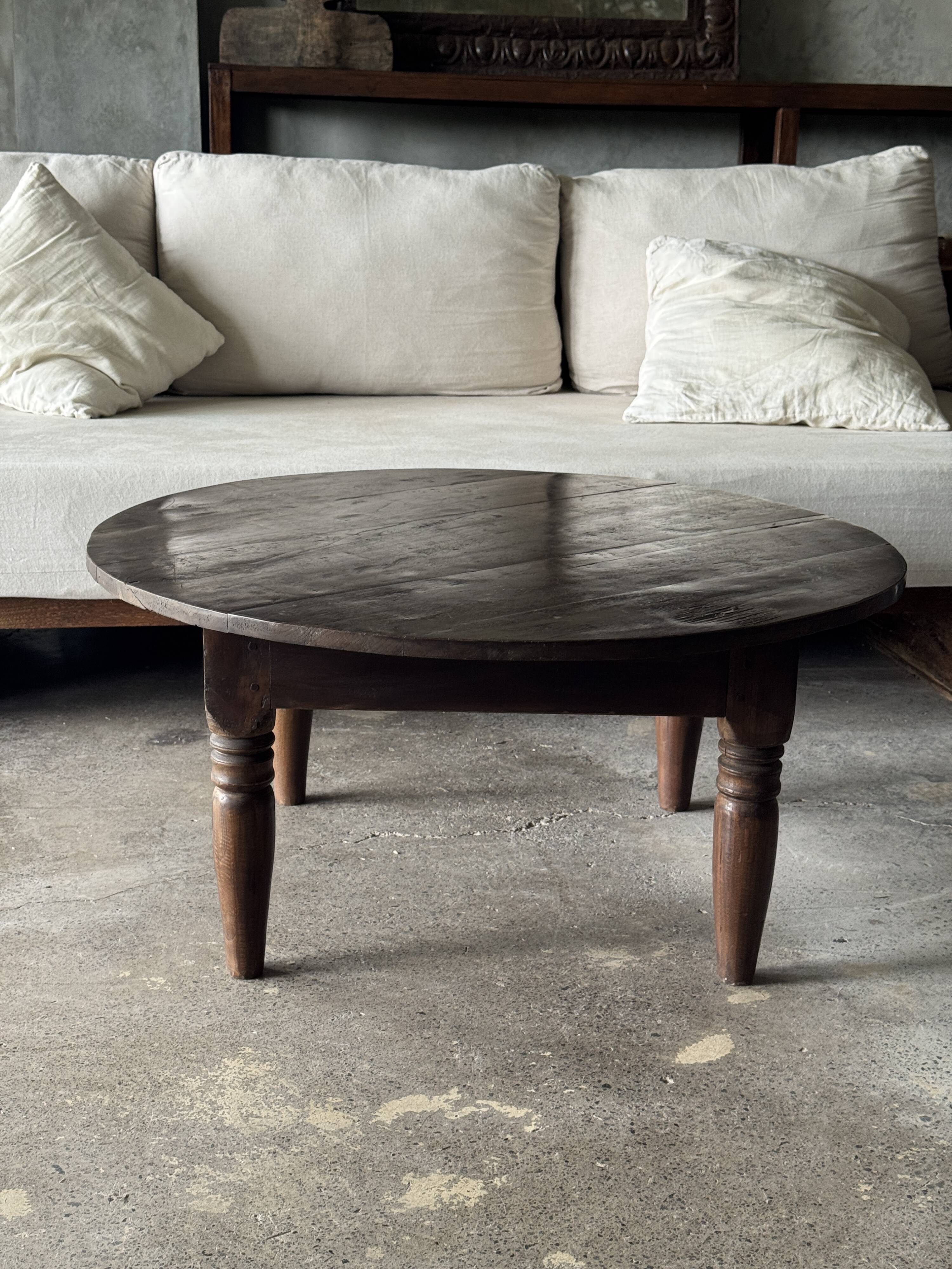 Coffee table, round antique Indonesian teak table with straight legs.
