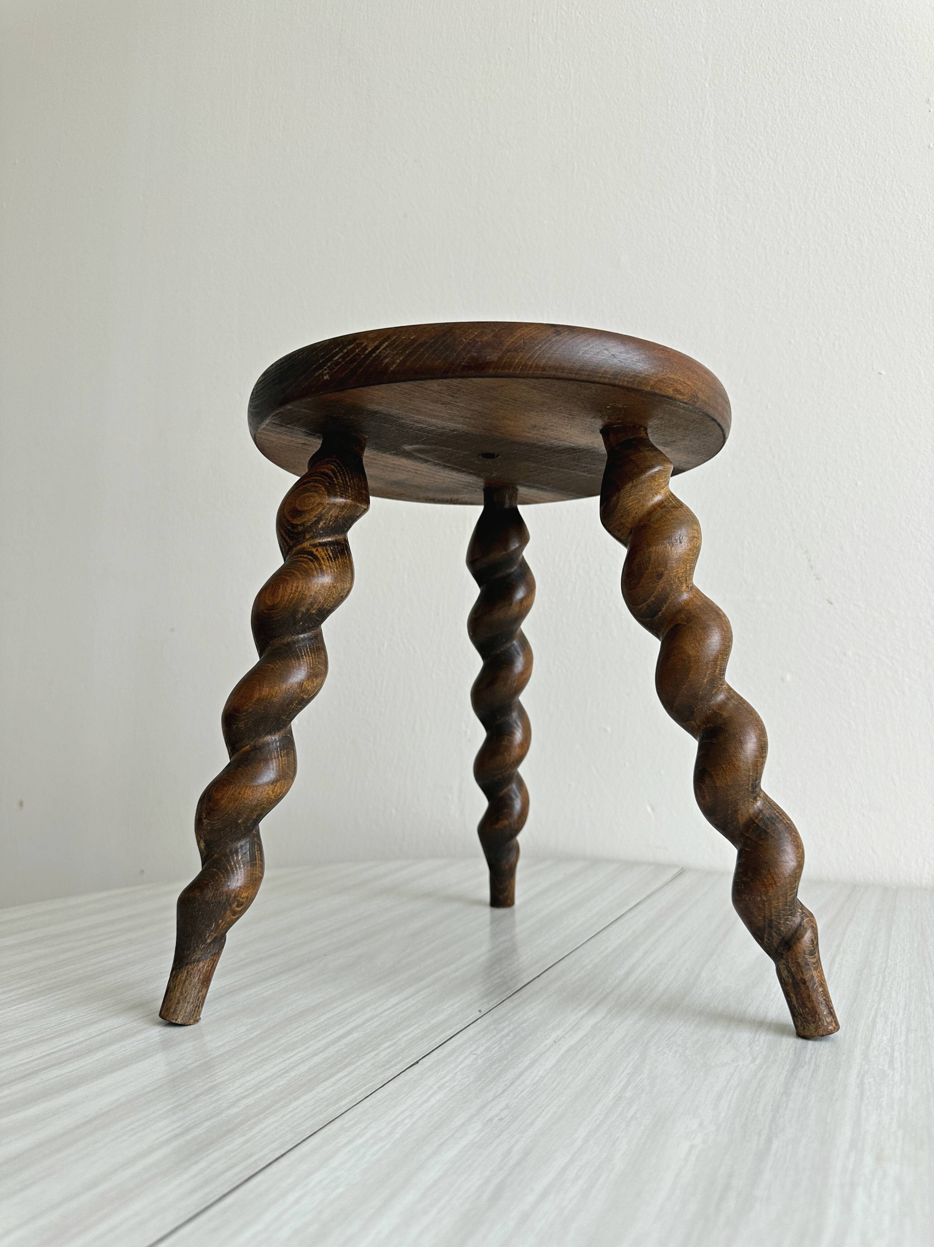 Small antique tripod stool in dark wood.