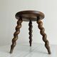 Small antique tripod stool in dark wood.