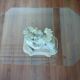 Glass table with carved wooden legs featuring intertwined fish.