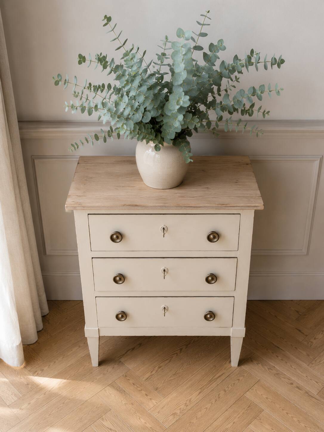 Petite commode classique sublimée en beige, plateau bois.