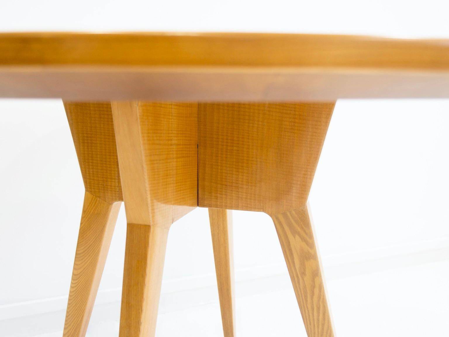 Round dining table in Wood Wood with brass details.