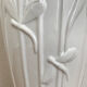 Old white art nouveau vase with flowers and dragonflies