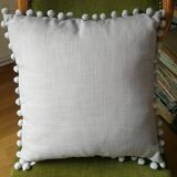 Gray cushion with pompoms