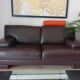 Two brown leather Crozatier two-and-a-half-seater sofas.