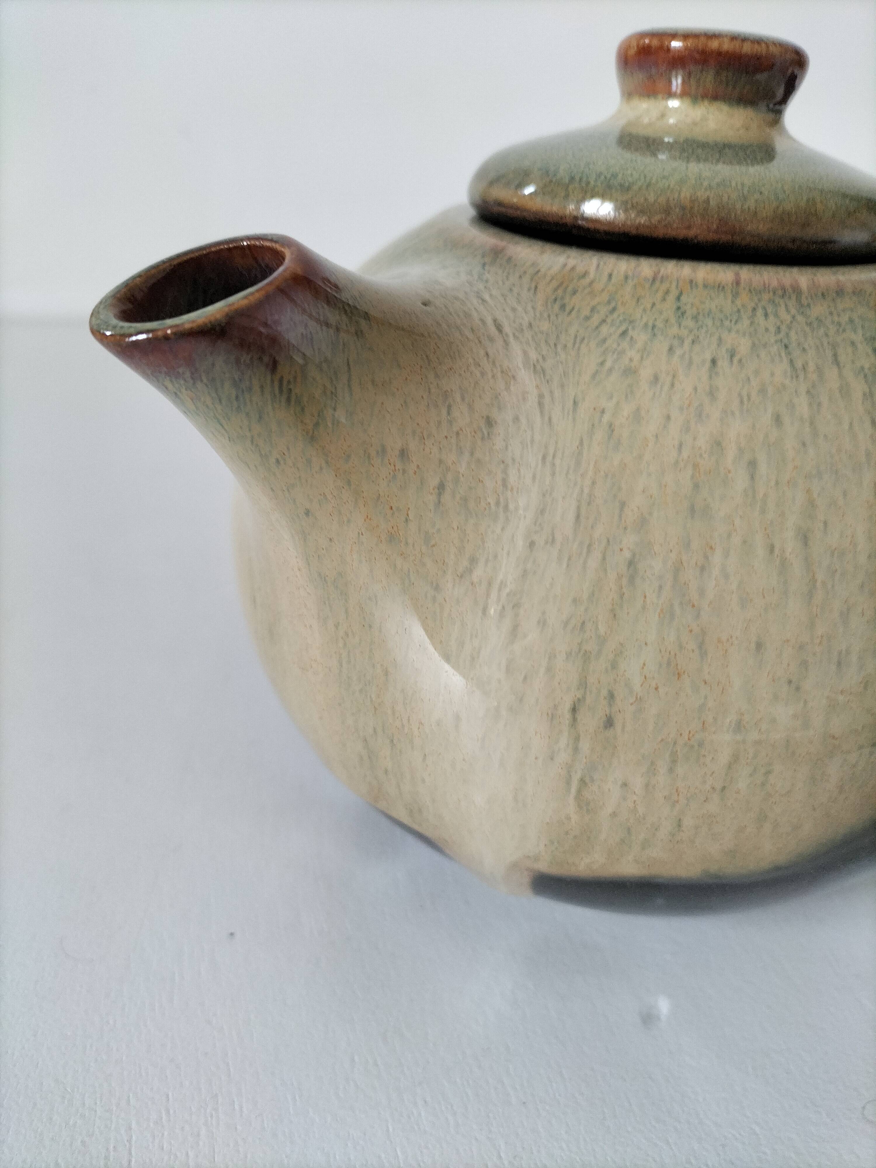 Vintage ceramic teapot with a flame design.