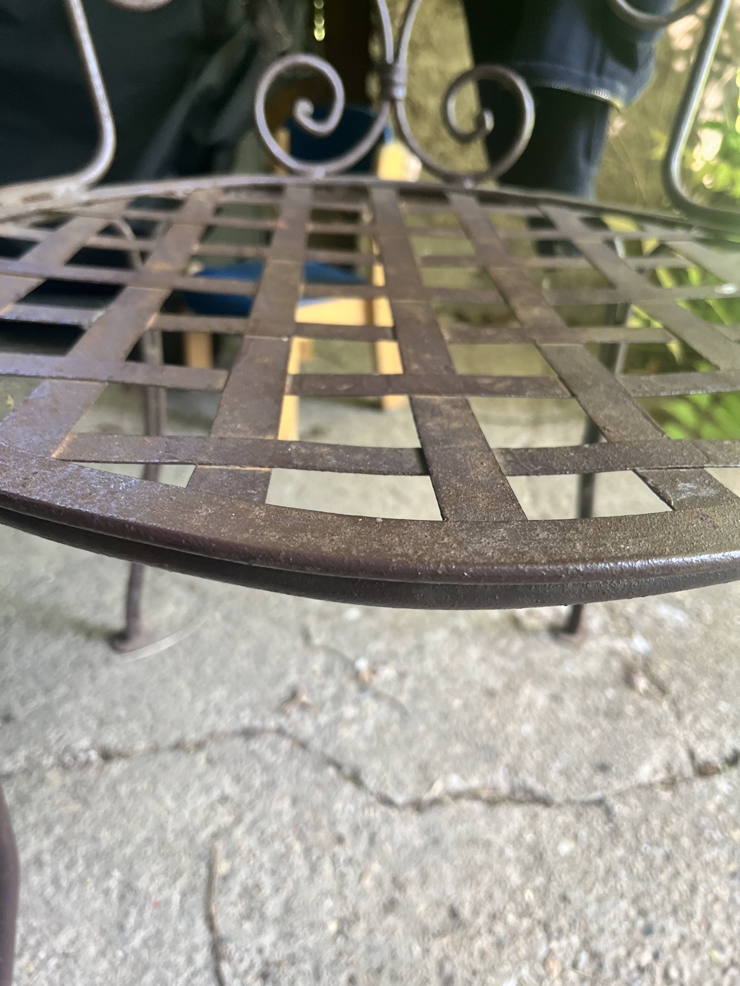Old wrought iron table and its armchairs and chairs for outdoor use.