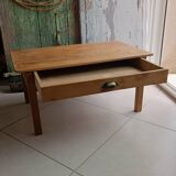 Coffee table with raw wood and a large drawer.