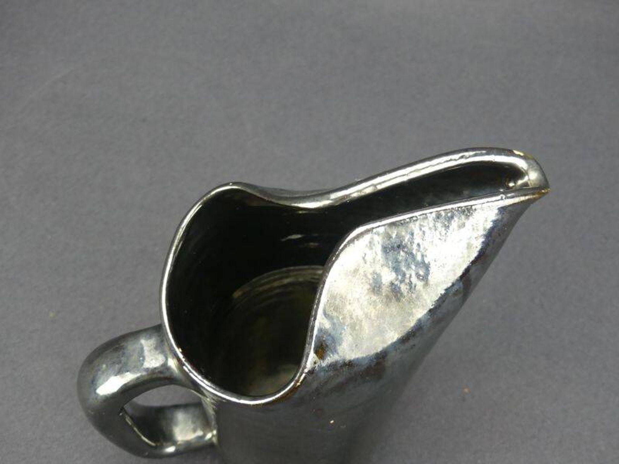 Old Biot, modernist pitcher in iridescent black ceramic.