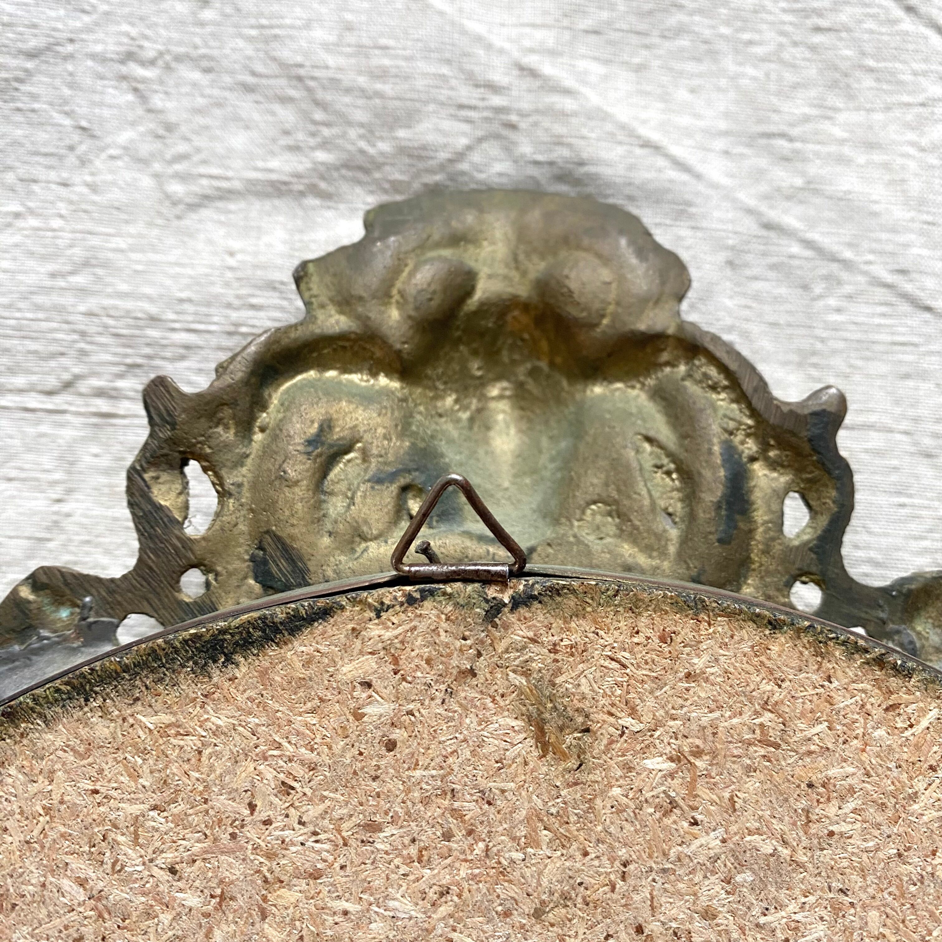 Antique oval brass crest mirror, 41x26 cm