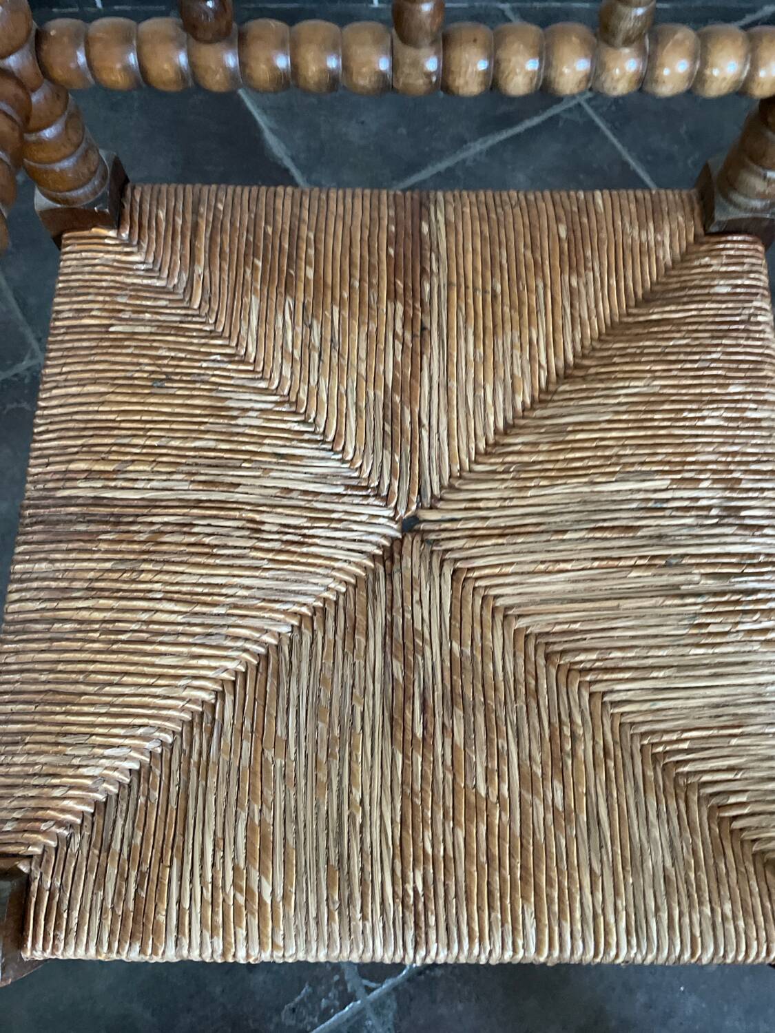 Old armchair, corner chair, made of wood and straw