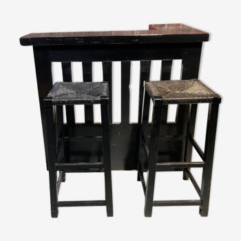 Bar set and its two blackened wooden stools.
