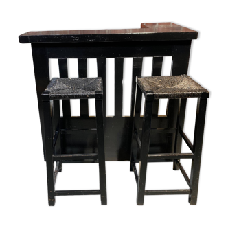 Bar set and its two blackened wooden stools.