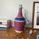 Old glass bottle and vintage scoubidou plastic weaving