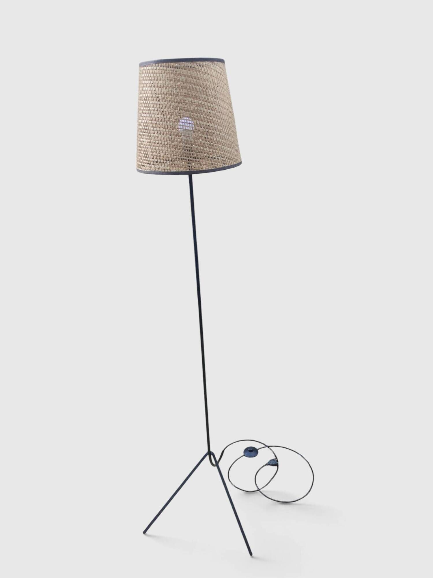 Modernist tripod floor lamp in black metal and cane from the 1950s/1960s.