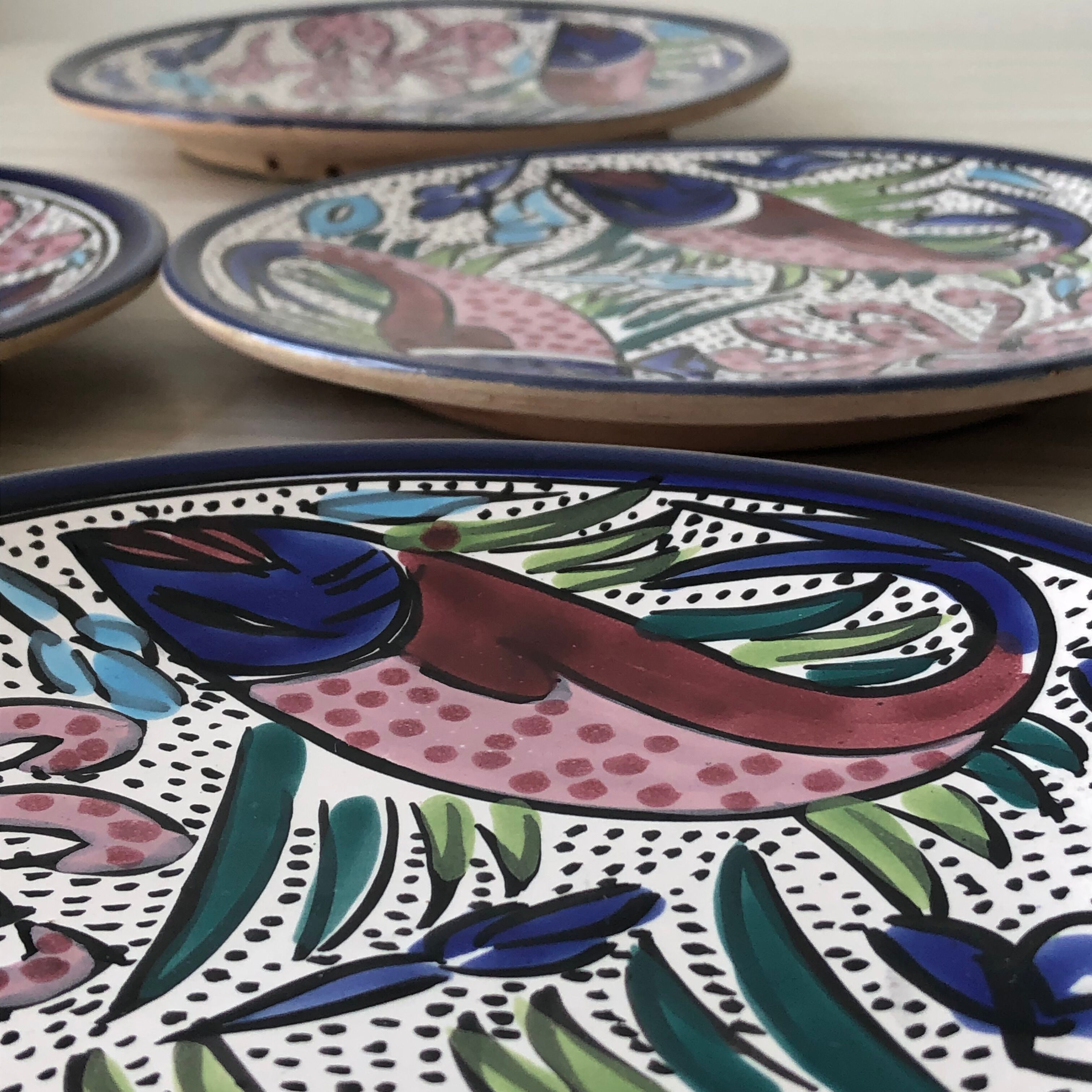 4 colorful flat plates with a fish pattern