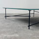 Minimalist black glass coffee table with industrial metal base