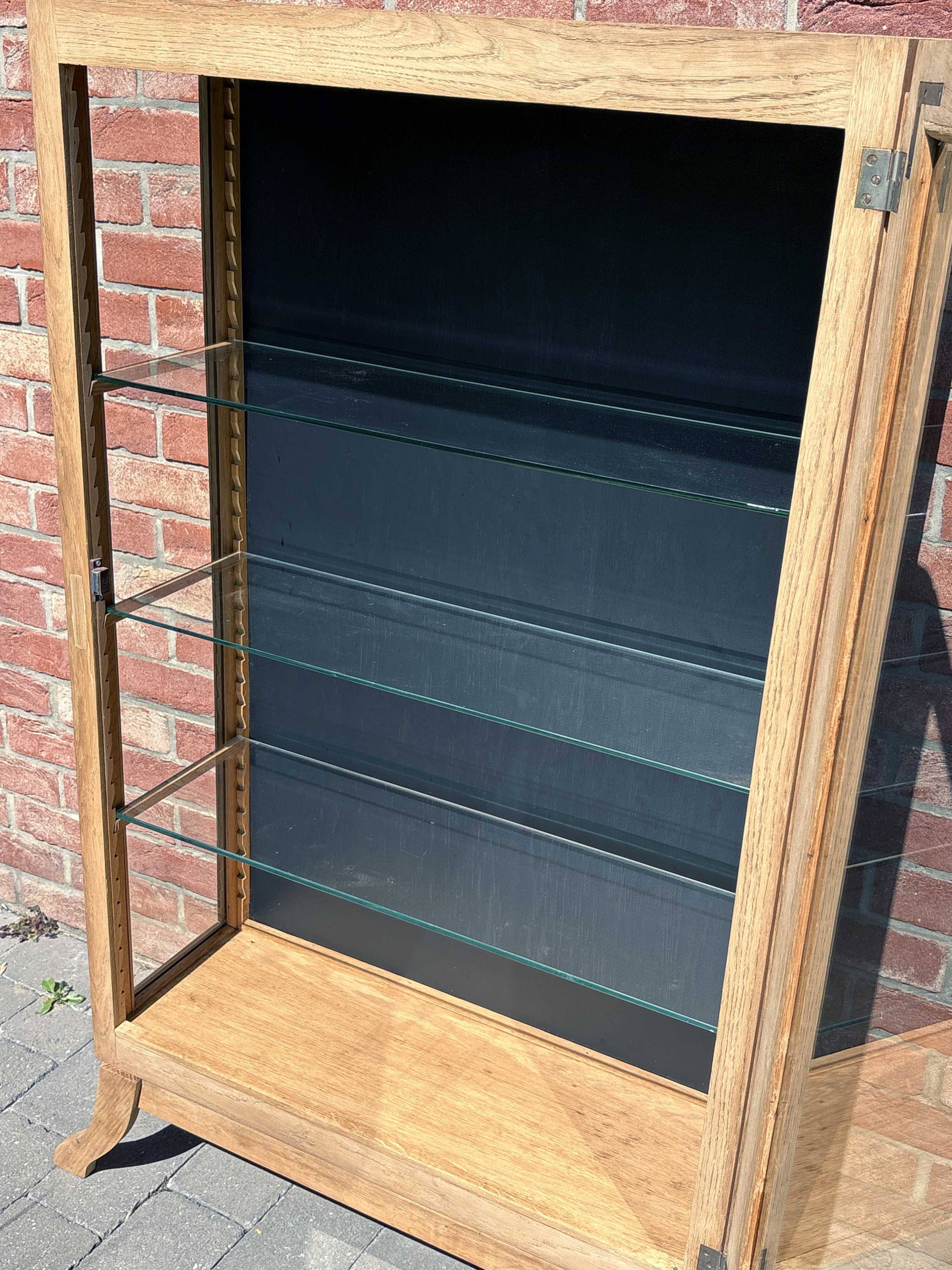Restored antique oak display cabinet, black background, glass shelves.
