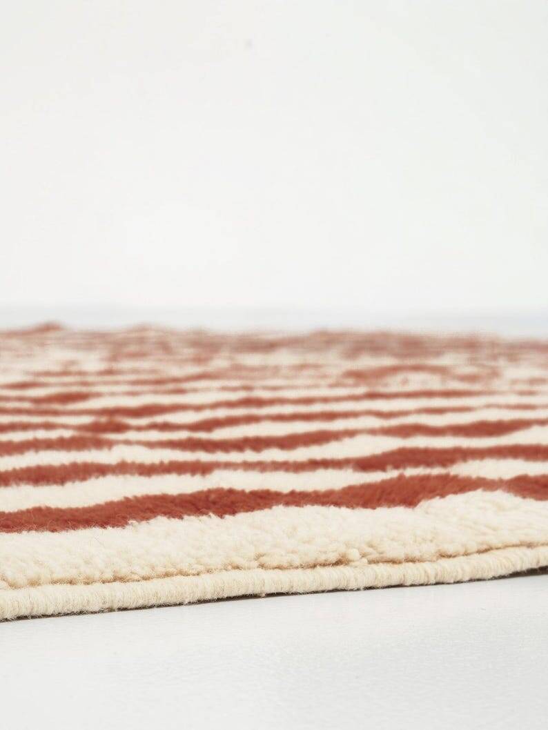 A handmade Moroccan striped terracotta rug, 150/250cm