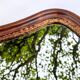 Antique wall mirror in carved wood with a wavy shape and a golden trim.