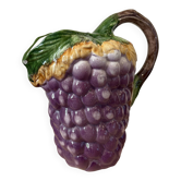Vintage jug in majolica with a bunch of grapes